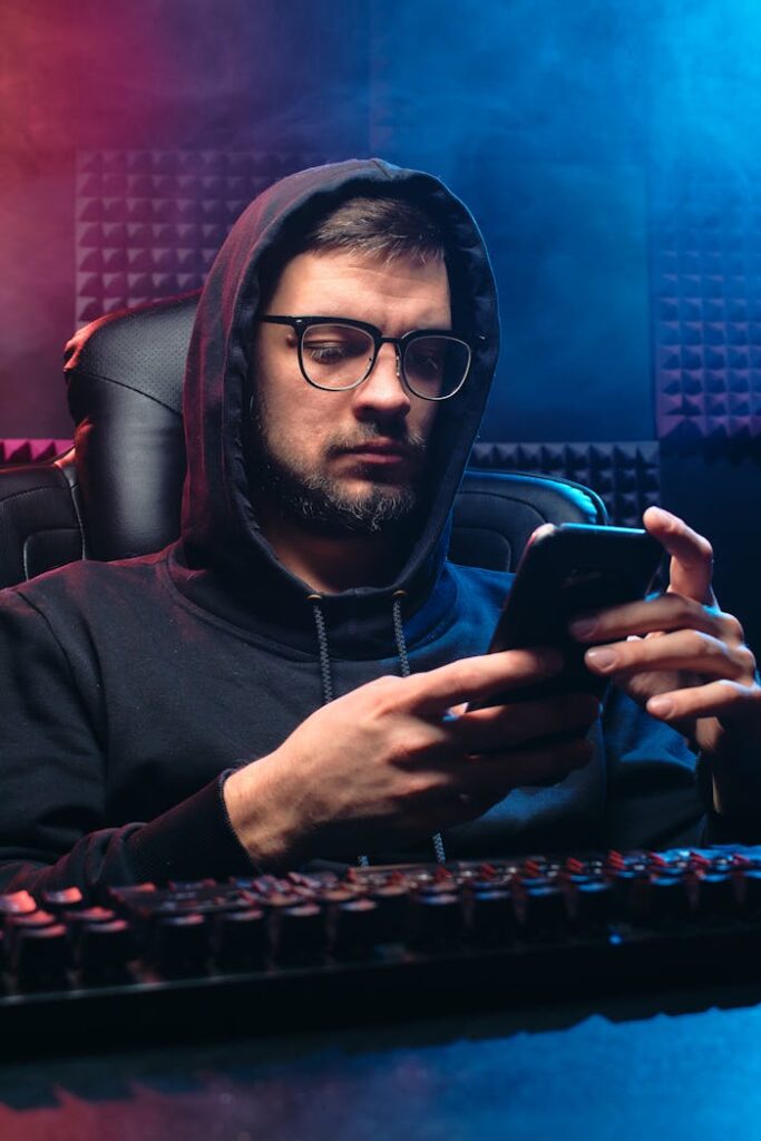 A Man in Black Hoodie Sweater Using His Mobile Phone